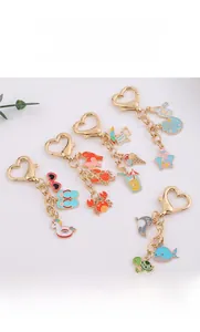 Detail view of summer ocean themed charms including whale and turtle on gold heart keyring