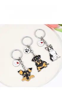 Detailed view of three cartoon dog enamel keychains on a white minimalist display