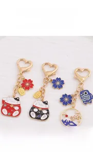 Close-up of Japanese style lucky cat and Fuji mountain metal enamel keychains