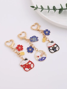 Detail of Maneki Neko keychains featuring cherry blossoms and Mount Fuji charms