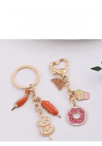Creative metal food keychains with glazed donuts and cupcakes on a white surface