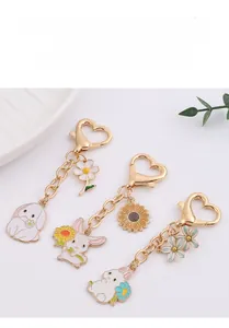 Detailed view of three cartoon rabbit keychains with floral motifs and heart-shaped hooks