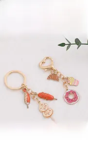 Detailed view of metal food keychains featuring cute croissant and BBQ skewer charms