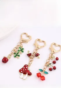 Detail of alloy keychains featuring cherry, mushroom, and clover charms with heart hooks