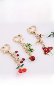 Detail view of alloy apple, cherry, and mushroom charms with golden heart-shaped clasps