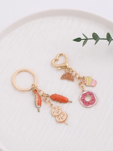 Close-up of creative food-themed metal keychains with mini donuts and cupcakes charms