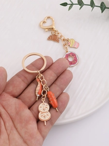 Detail of cute enamel dessert and BBQ skewer keychains with golden metal finish