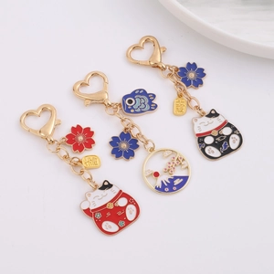 Japanese Maneki Neko lucky cat metal keychain with heart-shaped hook and cherry blossom charms