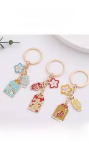 Detailed close-up of alloy cherry blossom keychains with koi and fortune amulets