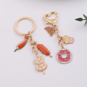 Metal food keychain featuring shrimp skewers and dessert charms with heart-shaped clip