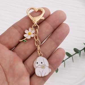 Creative cartoon bunny keychain with white daisy flower charm and golden heart clasp