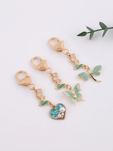 Detailed close-up of three dragonfly, butterfly and heart alloy charms with enamel finish