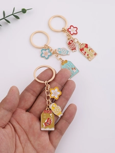 Close-up of Japanese style cherry blossom and lucky koi charms on alloy keychains