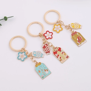 Japanese style cherry blossom omamori keychains in red, blue, and yellow alloy