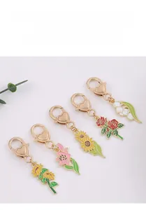 Détail d'un lot de cinq porte-clés floraux en métal avec motifs émaillés colorés