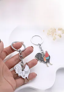 Detail of oil painting style rooster metal keychain with white and black red enamel finish