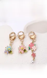 Détail de porte-clés floraux avec marguerites en émail et crochets en forme de cœur