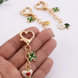 Golden heart-shaped lobster clasp keychain with clover and love enamel pendants
