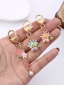 Détail d'un ensemble de porte-clés fleurs et coccinelle avec boucle coeur et perle