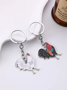 Detail of colorful enamel rooster keychains on white display stand with candle accessory