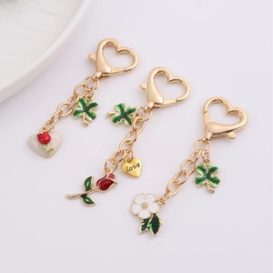 Golden heart-shaped keychain with red rose, clover charms and Love engraving pendant