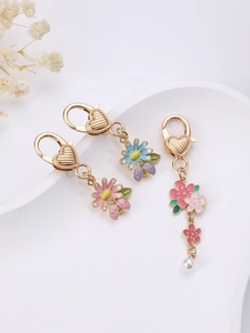 Détails des breloques florales en émail avec perles sur porte-clés dorés élégants