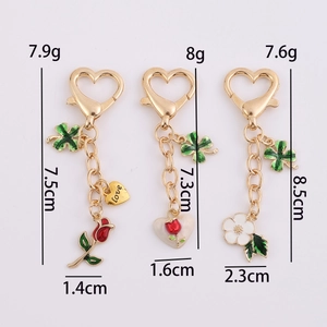 Golden heart keychain set with red rose and green four-leaf clover charms for luck