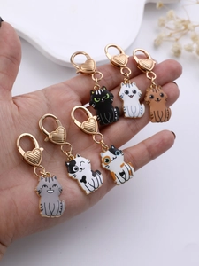 Detail of six cute cartoon cat keychains with heart-shaped golden clasps held in hand