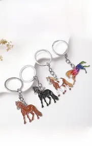 Detail of colorful horse-shaped metal keychains with vibrant enamel finish and key rings