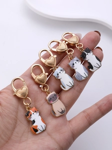 Close-up of five cute enamel cat charms with golden heart-shaped lobster clasps