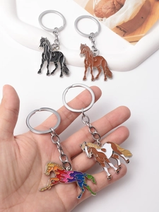 Close-up of four creative metal horse keychains in black, brown, spotted, and rainbow colors