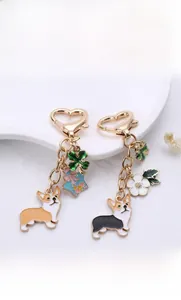 Detail of golden heart-shaped clasp and corgi pendant charms on a decorative white dish