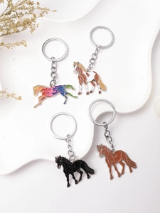 Detailed set of four colorful metal horse keychains with enamel horse pendants on white tray