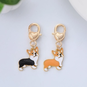 Detail of two enamel corgi charms with heart lobster clasps in black and orange colors