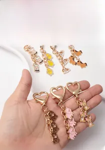 Detail of heart-shaped metal clasp and colorful enamel animal pendant for keychain