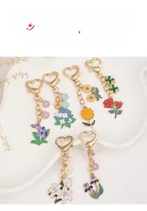Detailed close-up of floral metal keychains with colorful enamel in a ceramic tray