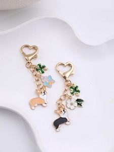 Detail of golden heart-shaped clasp with Corgi dog, clover, and star pendants charm