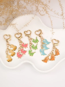 Detail showing five colorful dinosaur keychains with heart-shaped metal clasps