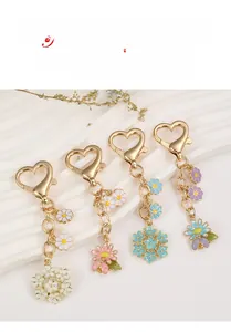 Detail of colorful enamel flower charms and heart-shaped carabiner on a metal keychain