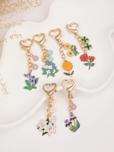 Set of six colorful enamel floral keychains with heart-shaped metal clips on a tray