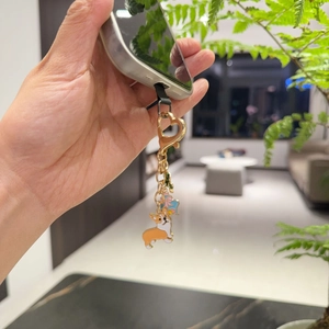 Golden heart lobster clasp keychain with Corgi pendant attached to a mobile phone