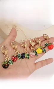 Detail of colorful fruit enamel keychains with heart-shaped golden alloy clasps