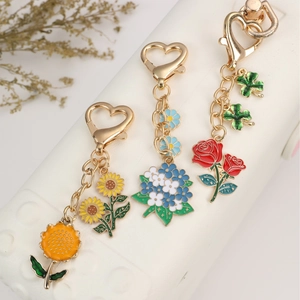 Colorful enamel flower keychains featuring sunflower, blue hydrangea and red rose designs