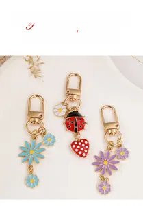 Detail of colorful enamel daisy and ladybug keychains with gold plating lobster clasp