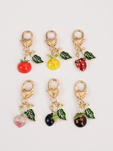 Detail of colorful fruit pendants including lemon and mangosteen with gold lobster clasps