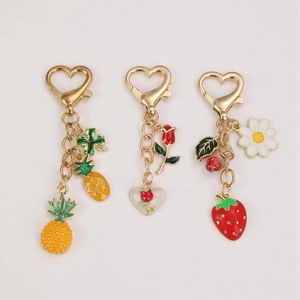 Fruit keychain collection with pineapple, strawberry and rose charms on gold heart clasps