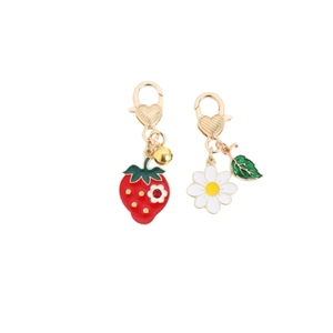 Golden heart clasp keychain featuring a strawberry charm and a white daisy pendant
