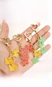 Colorful maple leaf keychain pendants with gold heart-shaped hooks in red and yellow