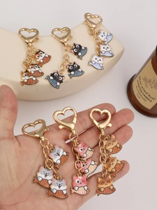 Detailed view of six cartoon cat taiyaki keychains with golden heart lobster clasps