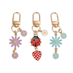 Daisy and ladybug keychain set with colorful enamel flower pendants and gold d-rings